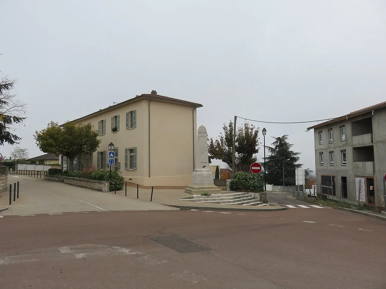 Le croisement entre les rues de Verdun et des Monts, avec au centre le monument aux morts et à gauche la mairie, à Sainte-Consorce (Rhône, France).